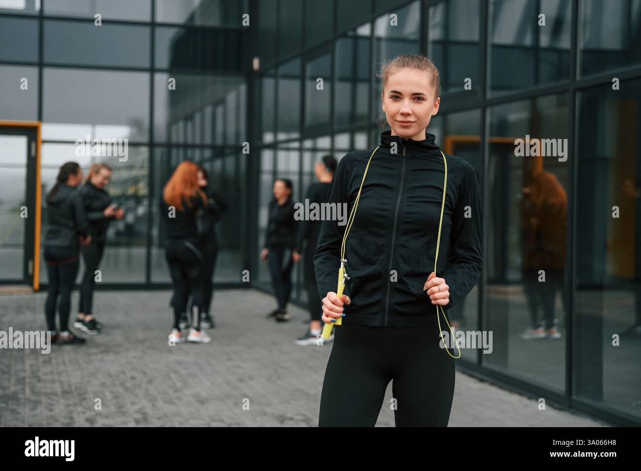 Un gruppo di donne sportive si trova all'aperto vicino all'edificio nero. Foto Stock