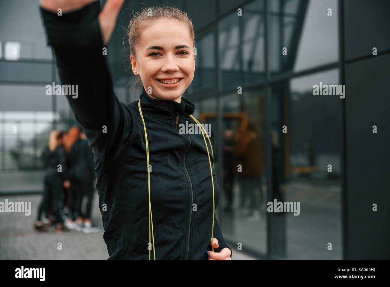 Fare selfie. Un gruppo di donne sportive si trova all'aperto vicino all'edificio nero. Foto Stock