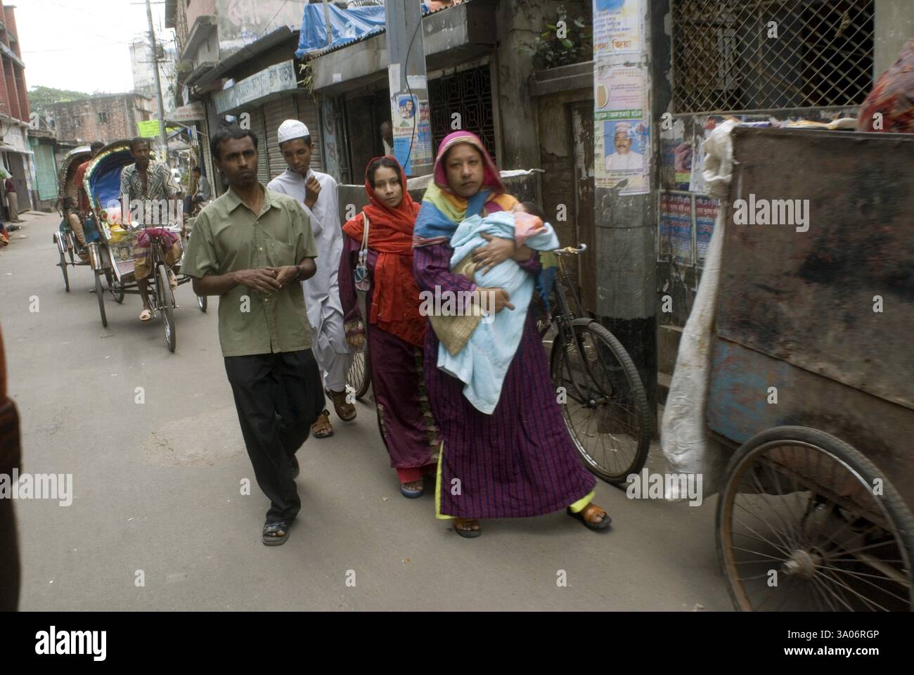 Persone che camminano su strada e ciclismo Rickshaw Riders Behind, Dacca, Bangladesh, Asia Foto Stock