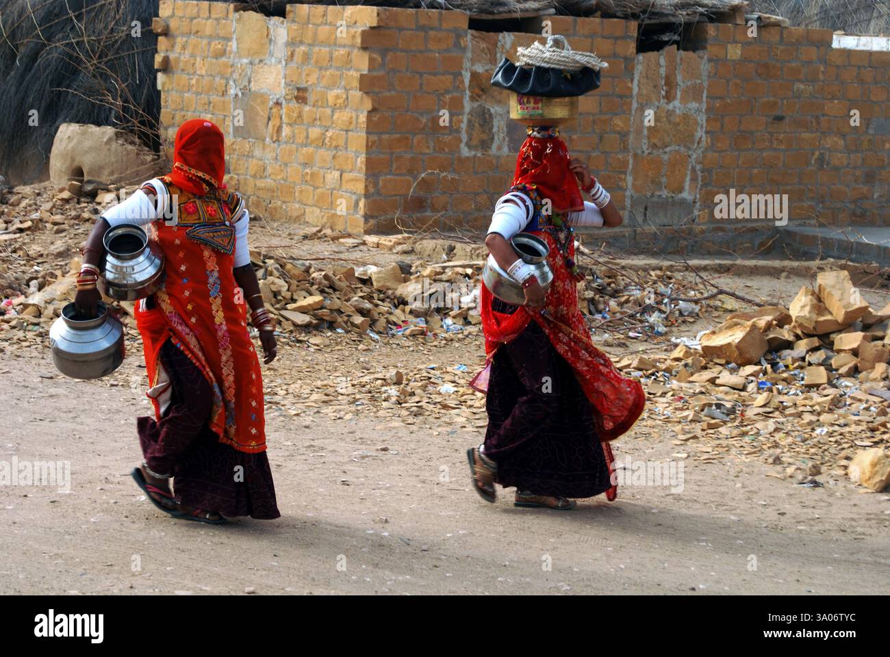 Due donne del villaggio Rajasthani Marwari con vasi che vanno bene a prendere l'acqua, Khuhri, Jaisalmer, Rajasthan, India NO MR Foto Stock