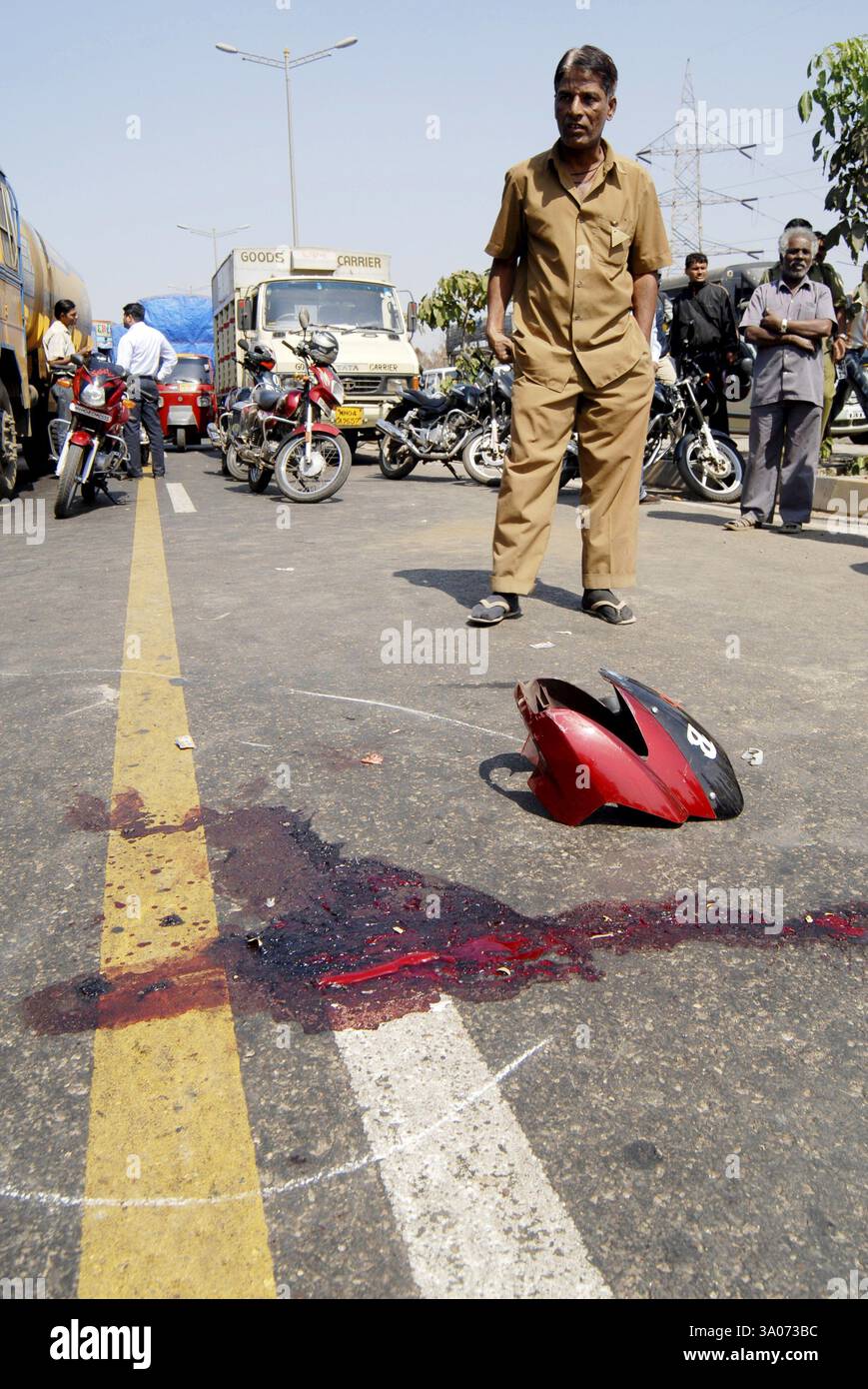 Uomo che cerca sangue e parte spezzata di un incidente su due ruote sull'autostrada a Bombay Mumbai, Maharashtra, India NO MR Foto Stock