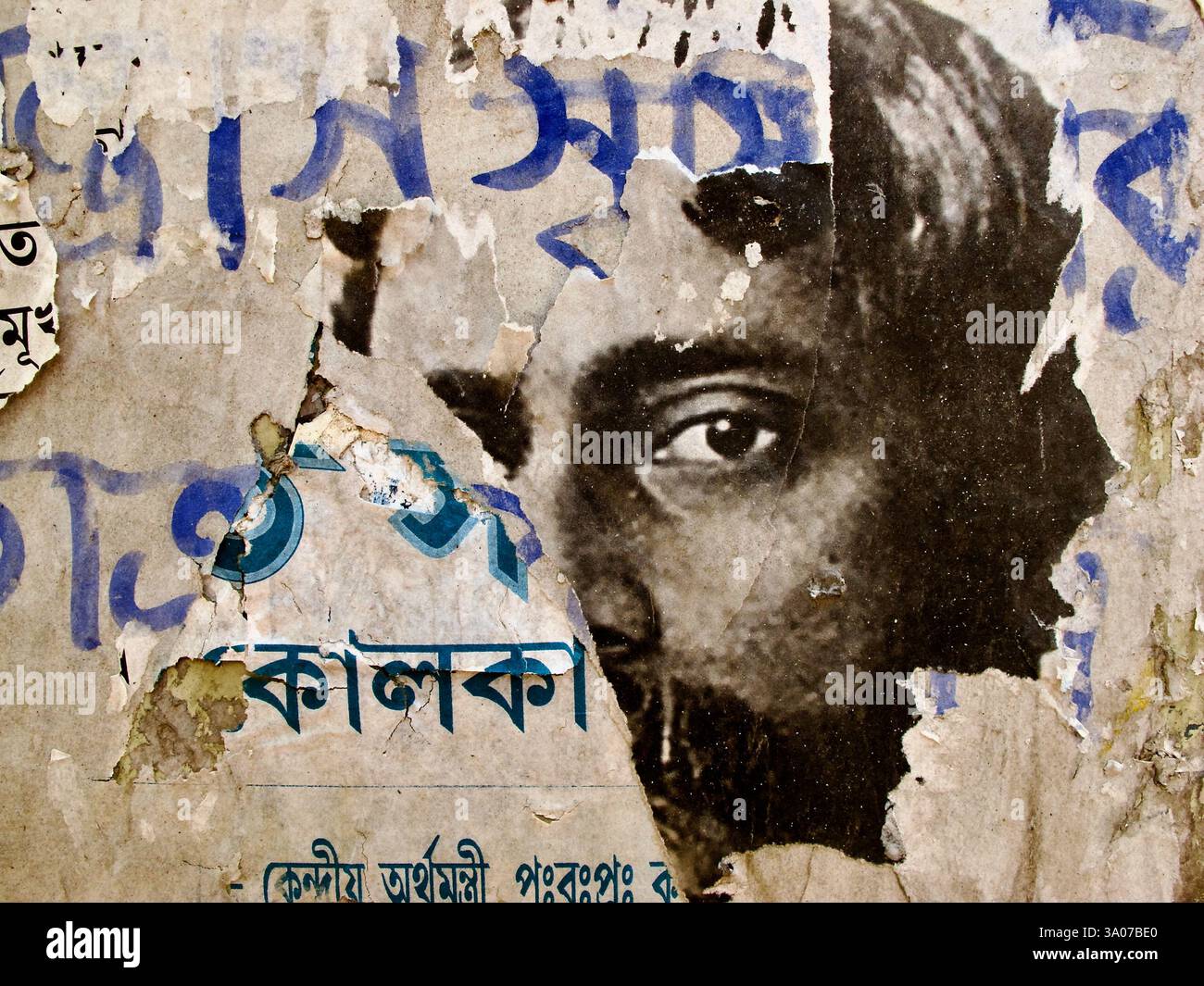 Strati di manifesti strappati su un muro intempestivo in Shantiniketan rivelano un ritratto frammentato di Rabindranath Tagore, che riflette il tempo e il decadimento. Foto Stock