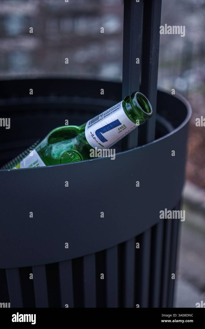 Varsavia, Polonia. 26 gennaio 2025 - bottiglia di birra analcolica vuota gettata in un cestino dei rifiuti Foto Stock