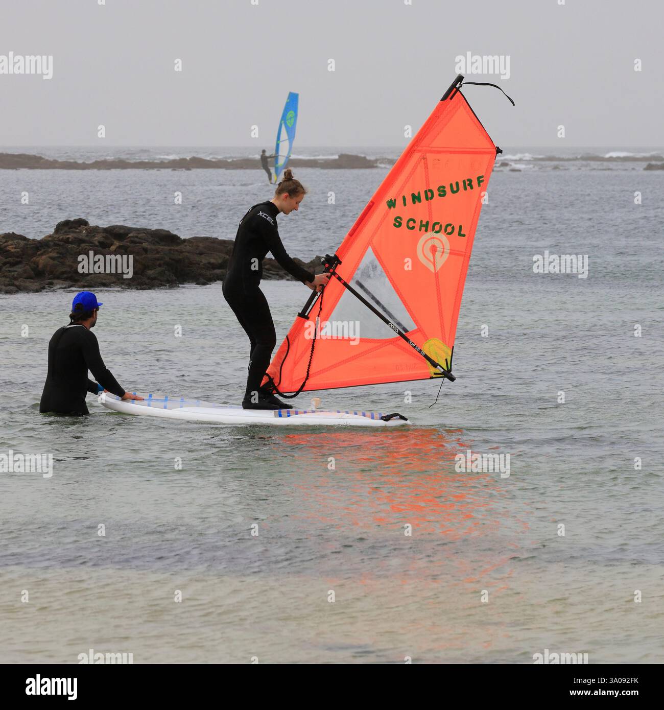 Giovane donna che prende lezioni di windsurf a El Cotillo, Fuerteventura. Preso il 2024 dicembre. Inverno Foto Stock