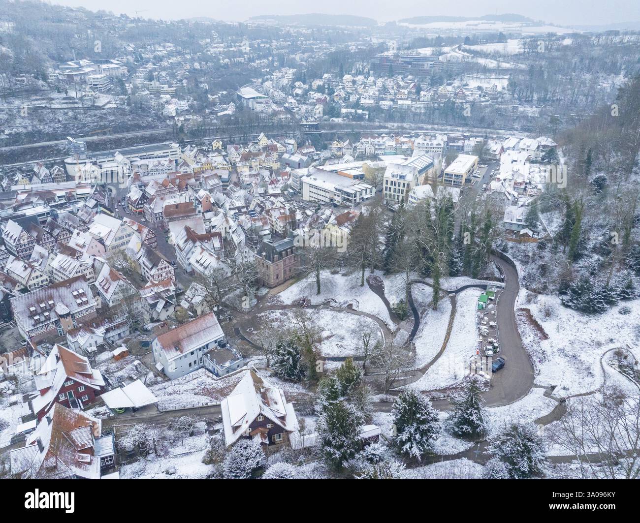 Vista aerea di un paesaggio urbano innevato con colline, nuova passerella in legno nel giardino della città di Calw, Calw, Foresta Nera, Germania, Europa Foto Stock