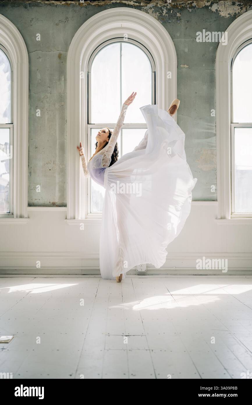 Ballerino di balletto in un abito fluente esegue un alto arabesco en pointe Foto Stock