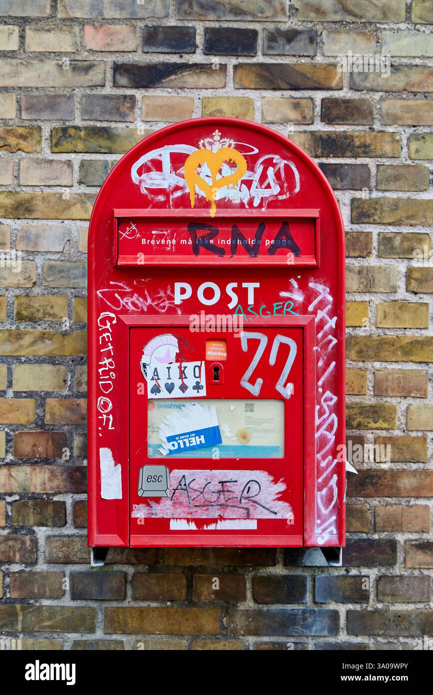 Casella di lettere danese (postkasse) coperta da adesivi e graffiti; Copenaghen, Danimarca Foto Stock