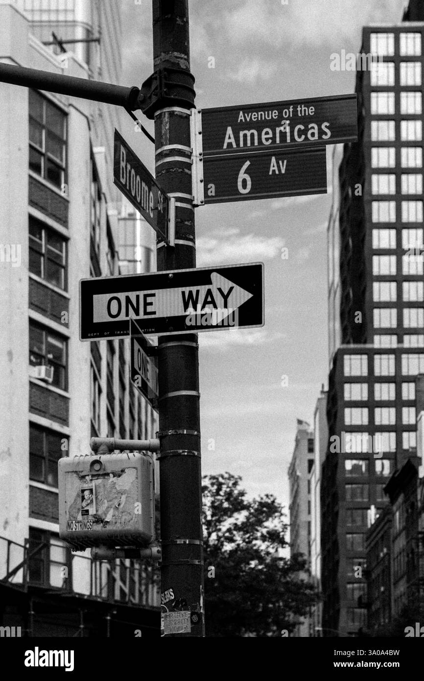 Immagine in bianco e nero dei cartelli della 6th Avenue a New York, con edifici storici e urbani Foto Stock