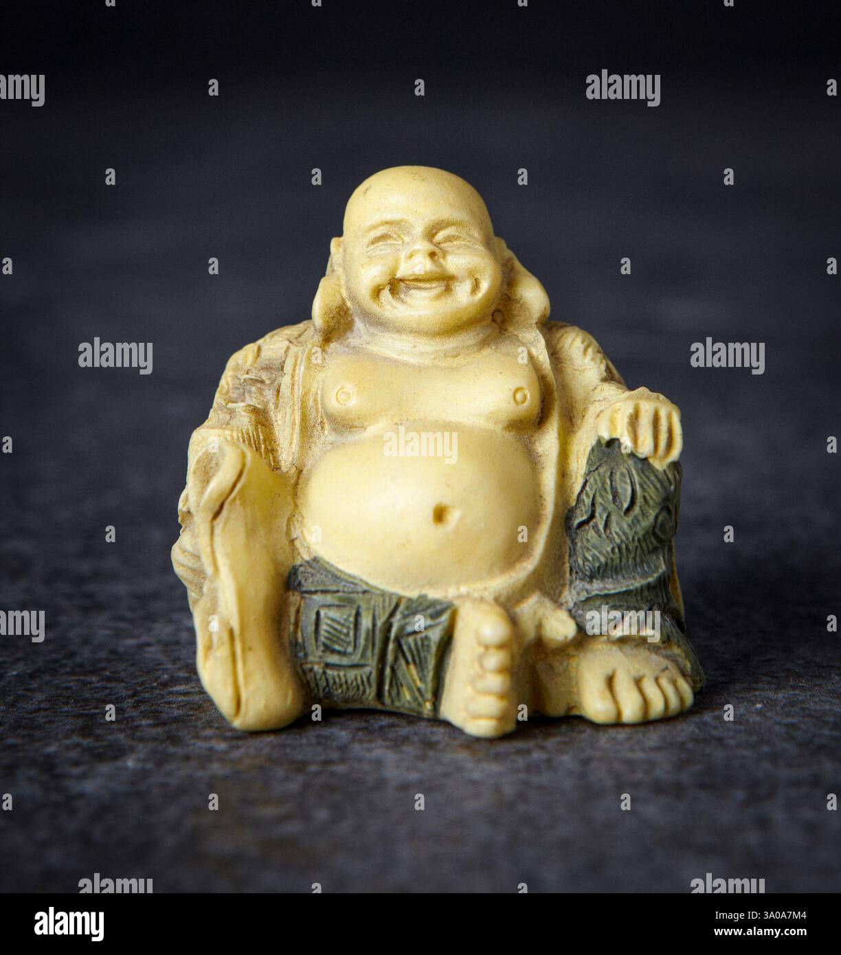 Natura morta di una statua di buddha ridendo, Buddha robusto e panciuto, sorriso contento sul suo viso. Considerato simbolo di buona fortuna, felicità e Plentitudine. Foto Stock