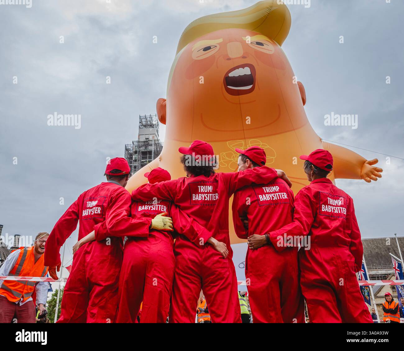 Trump Babysitters circondano un gigantesco pallone aerostatico di Donald Trump in Parliament Square a Londra, protestando contro la sua visita nel Regno Unito. Foto Stock