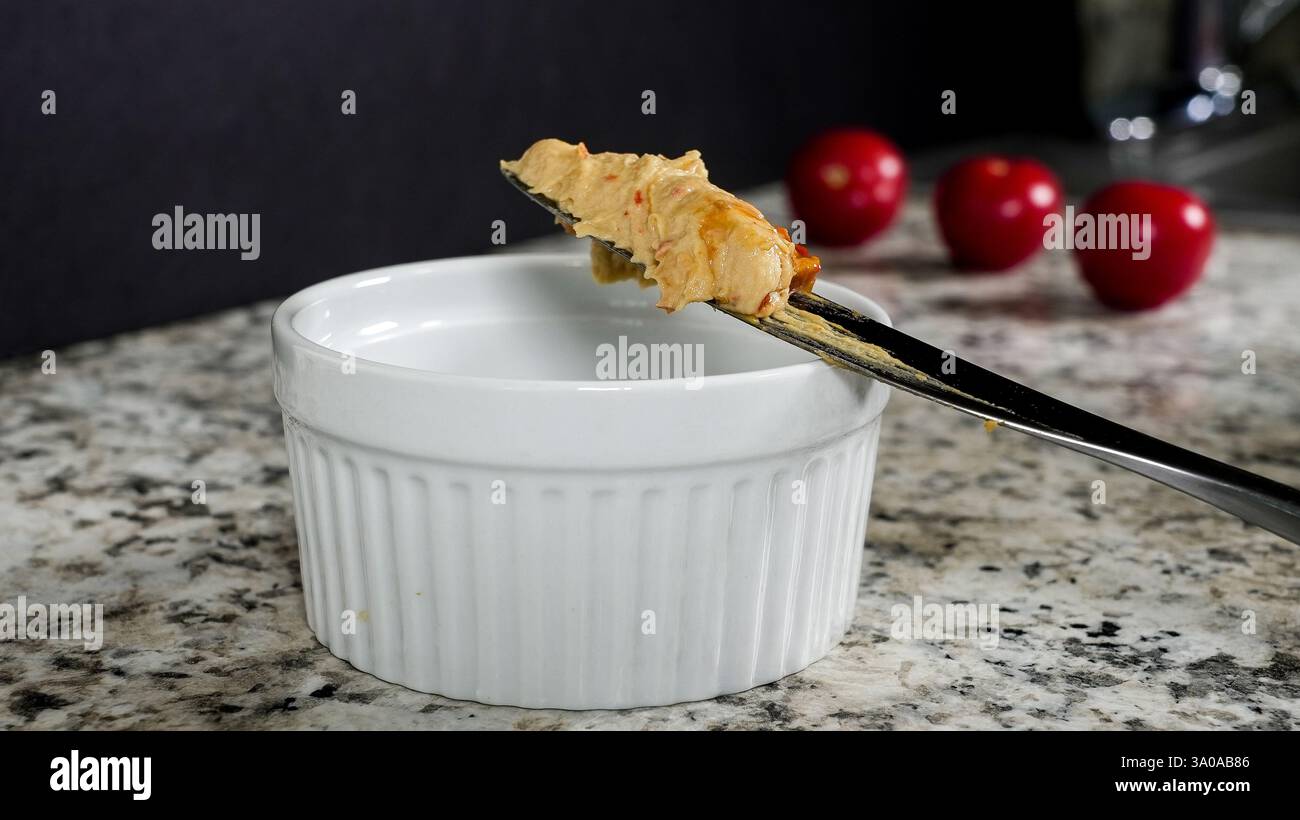 Coltello da tavolo con hummus su un ripiano in granito con spazio di copia Foto Stock