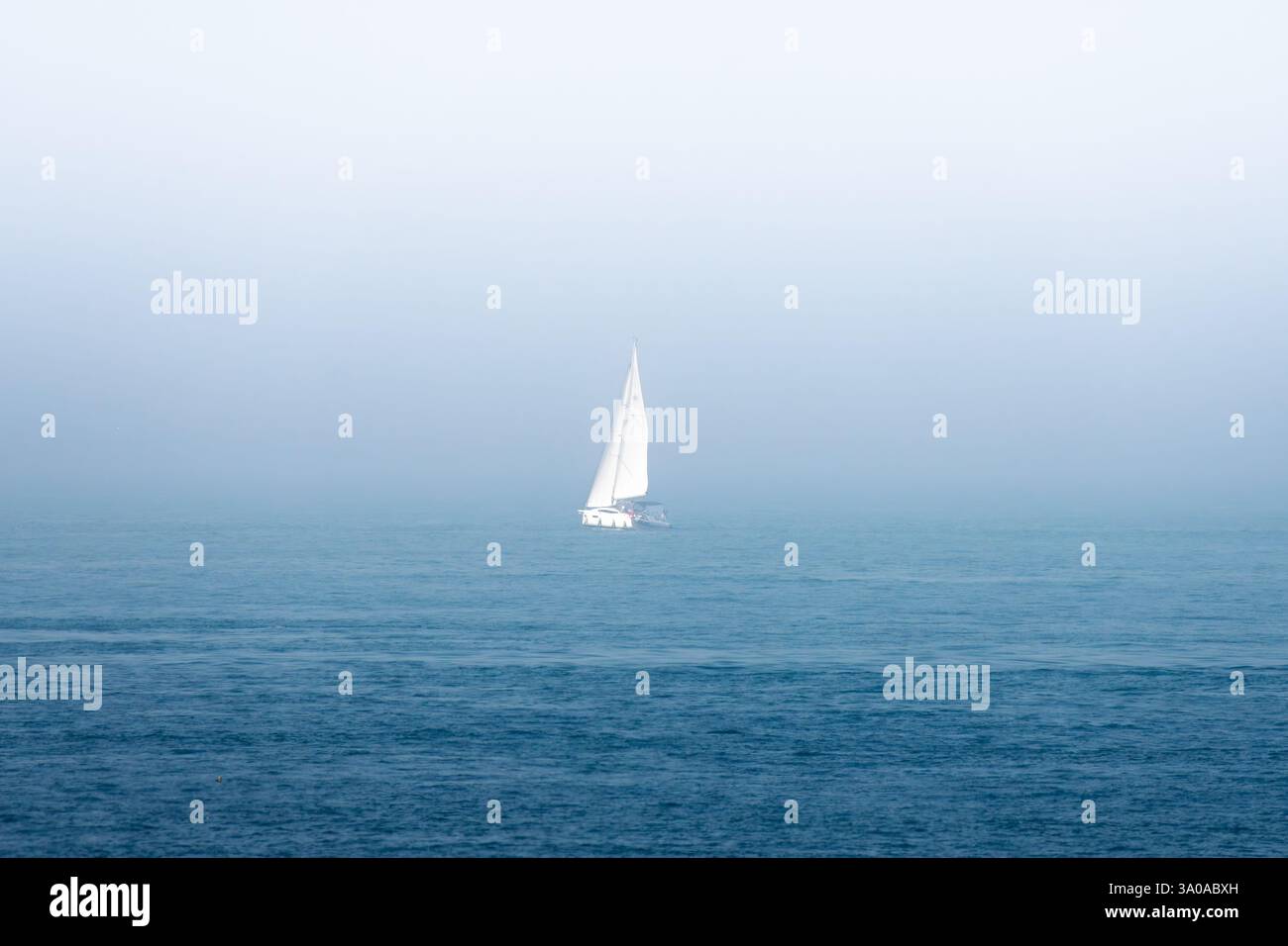 Una barca sul mare con il tempo nebbioso Foto Stock