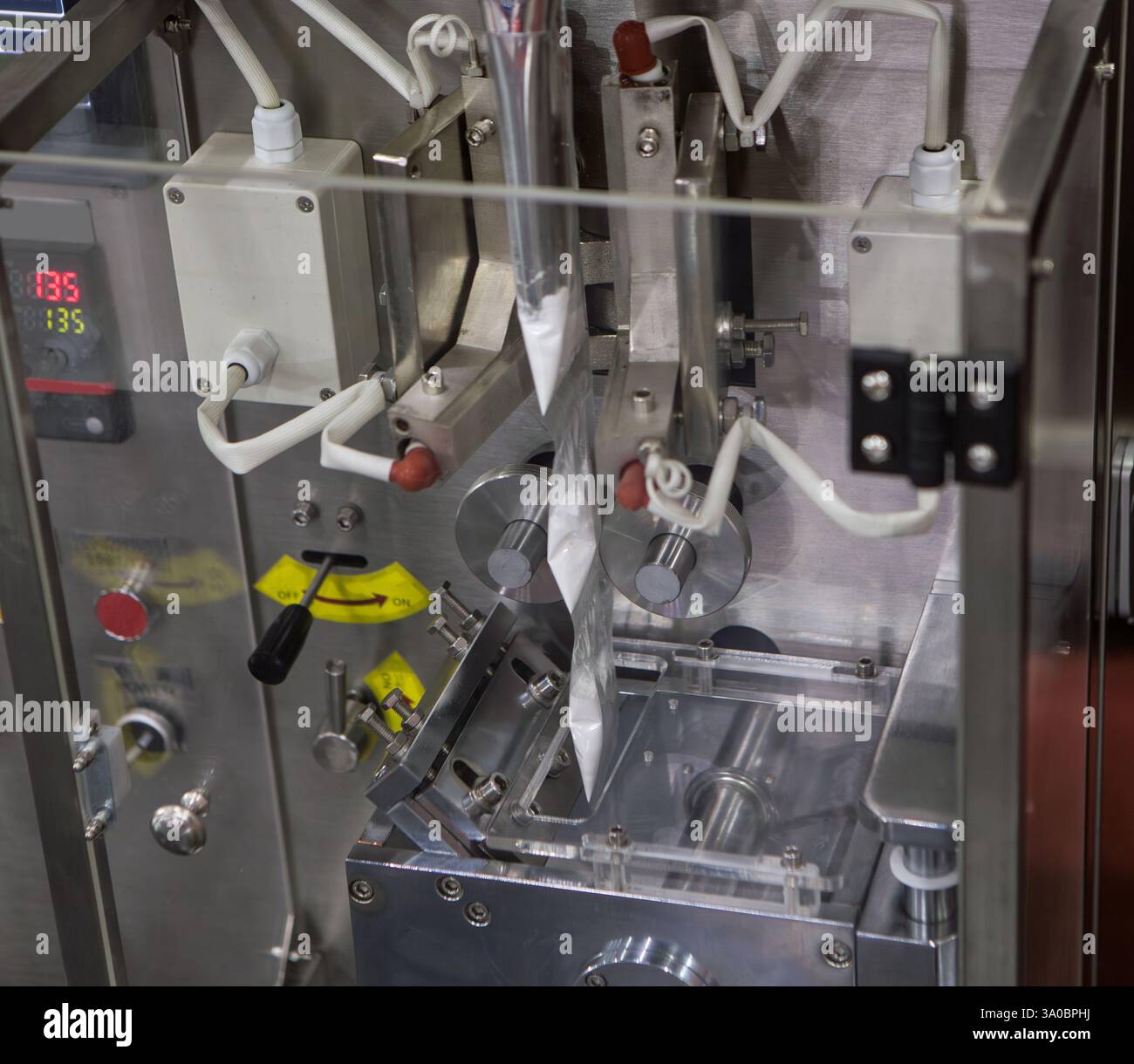 Macchina per il riempimento e il confezionamento verticale di bustine di salsa nell'industria alimentare Foto Stock
