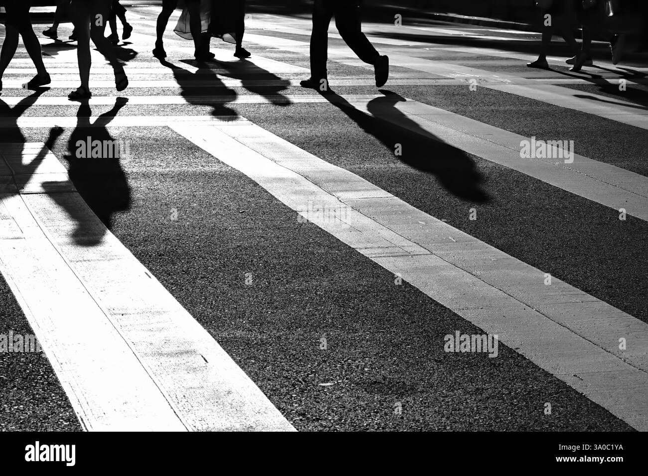 Fotografie artistiche in bianco e nero, prospettiva di una passeggiata pedonale a righe con gambe sagomate e ombre umane Foto Stock