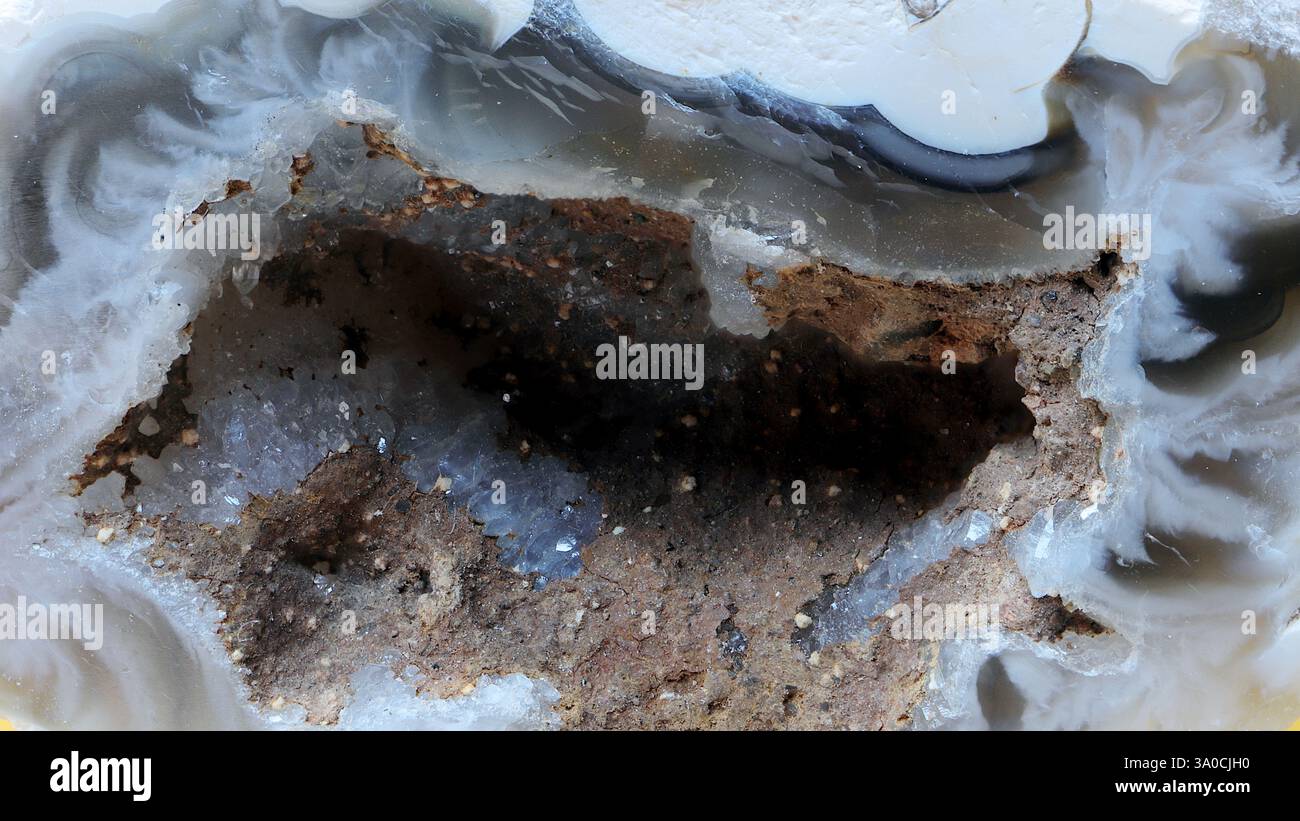 L'apertura granulosa di un piccolo geode. Vista attraverso un obiettivo macro, una superficie grossolana di un foro profondo. Geologico. Foto Stock