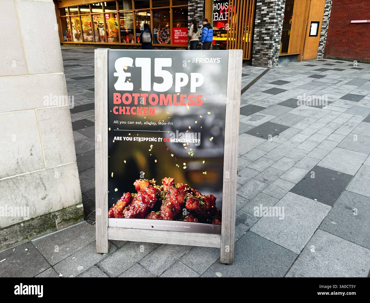 Londra, Regno Unito - 2 marzo 2025: Poster promozionale TGI Fridays con un'offerta di pollo all you CAN eat all'esterno di un ristorante Foto Stock