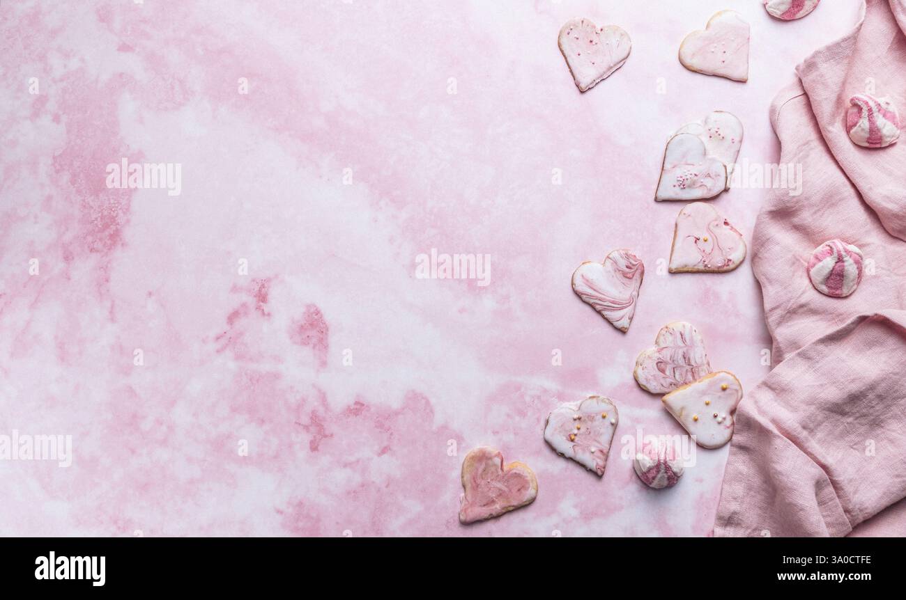 Biscotti a forma di cuore decorati in casa su sfondo rosa, regalo per san valentino, vista dall'alto con spazio per fotocopie Foto Stock