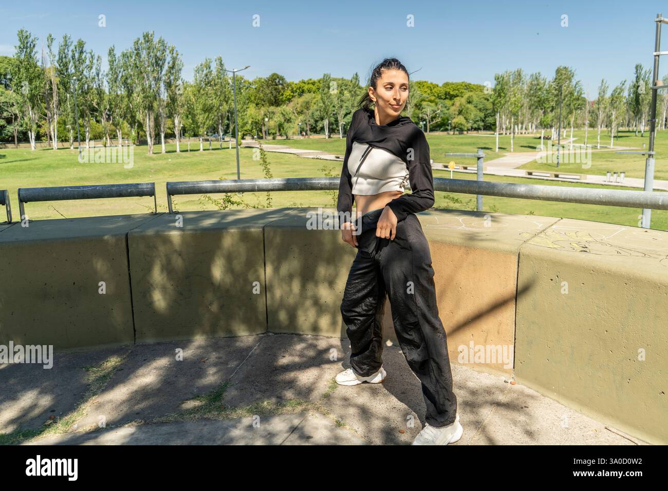 Donna che balla con gioia in un vivace parco cittadino Foto Stock