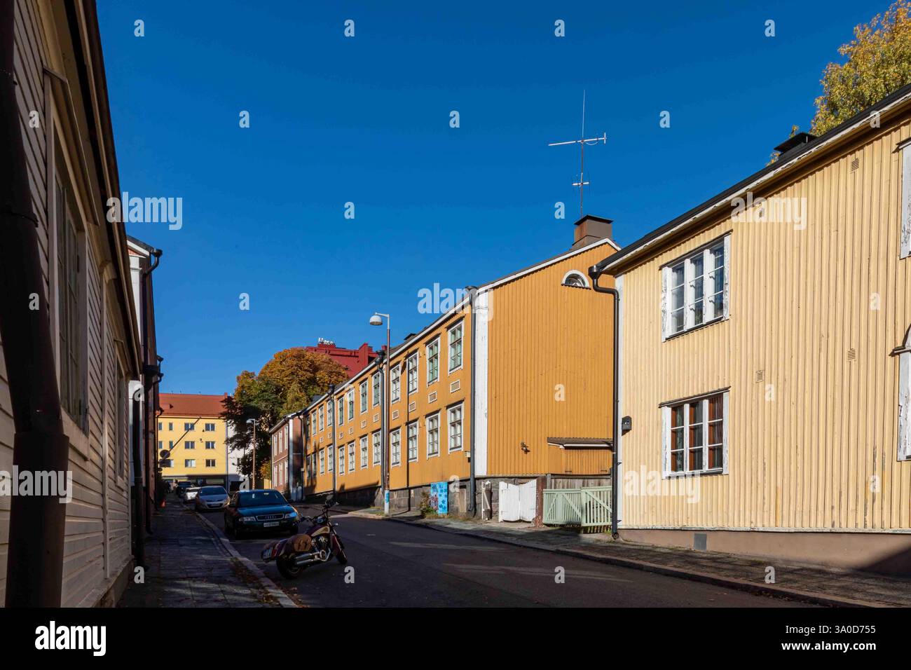 La vista sulla strada Vanajantie con edifici residenziali in legno si estende su un cielo azzurro nel quartiere Puu-Vallila di Helsinki, Finlandia Foto Stock