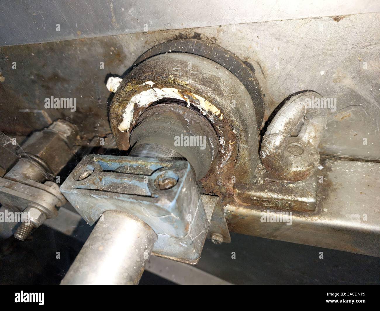 La vista ravvicinata del supporto del cuscinetto rivela segni di ruggine e usura, evidenziando l'importanza della manutenzione nei macchinari industriali per prestazioni ottimali Foto Stock La vista ravvicinata del supporto del cuscinetto rivela segni di ruggine e usura, evidenziando l'importanza della manutenzione nei macchinari industriali per prestazioni ottimali Foto Stock