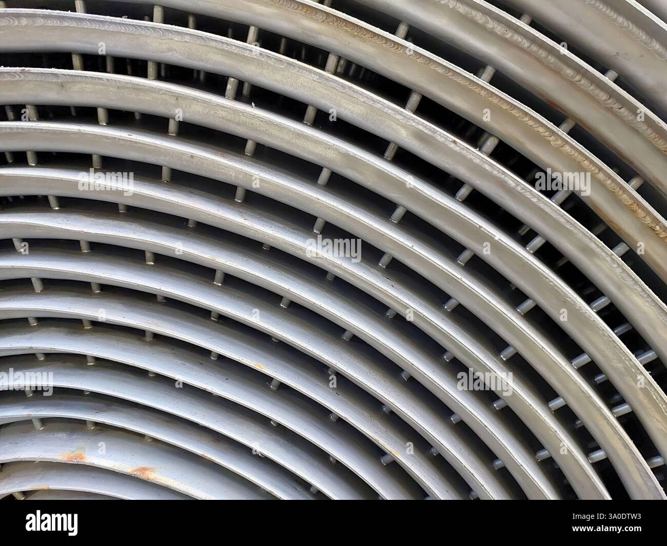 Uno scambiatore di calore a spirale in acciaio inox è caratterizzato da un design complesso che migliora il trasferimento di calore e aumenta le prestazioni nelle applicazioni industriali. Foto Stock