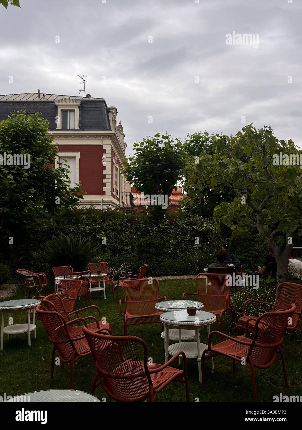 Un tranquillo ambiente da caffè all'aperto caratterizzato da affascinanti posti a sedere in mezzo al verde Foto Stock