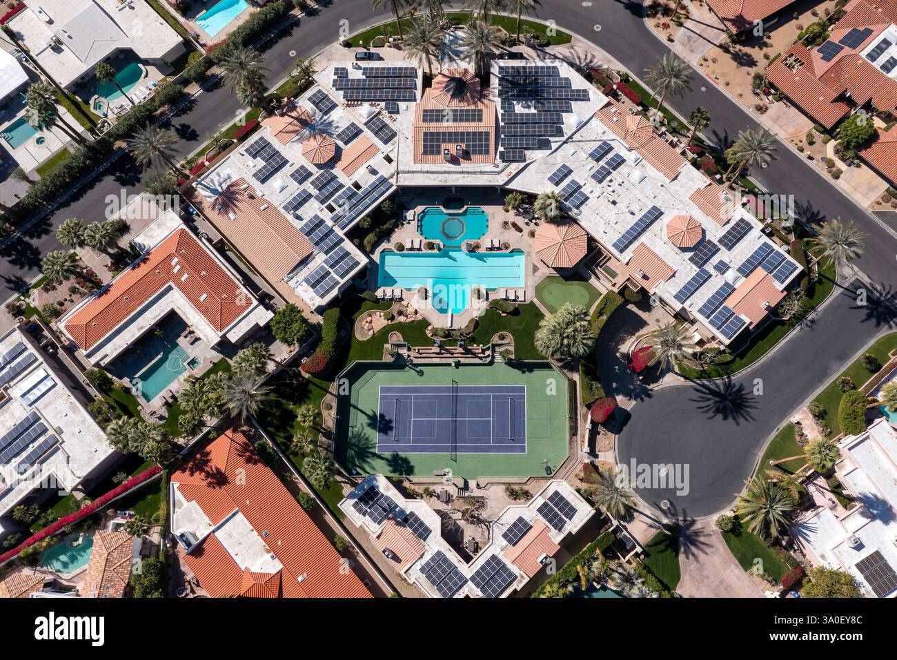 Vista aerea di una grande casa di lusso con piscina e un campo da tennis/picnic in un quartiere esclusivo. Foto Stock