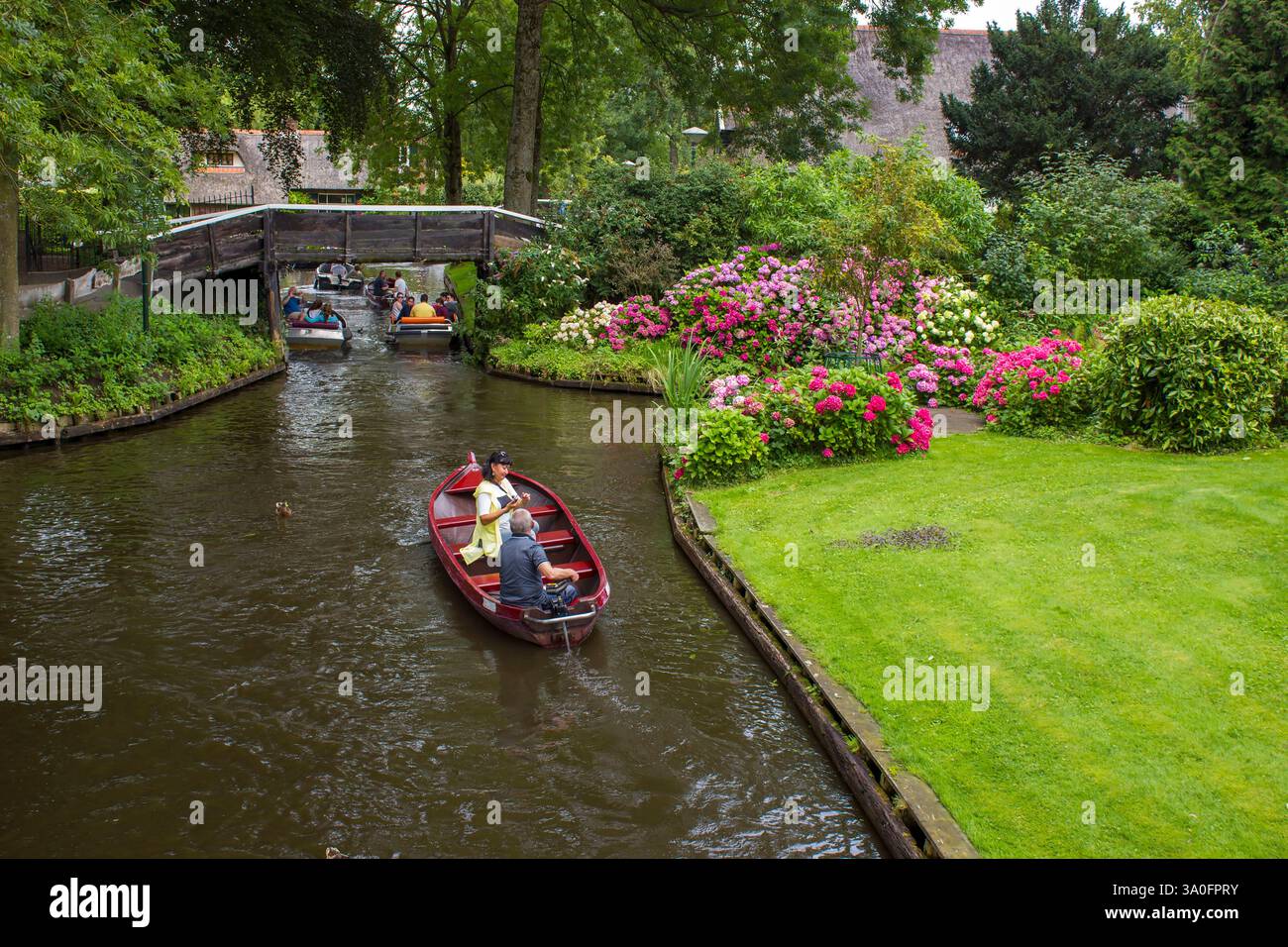 GIETHOORN, PAESI BASSI - AGOSTO 01 2017: Visitatori sconosciuti nel giro turistico in barca in un canale a Giethoorn. Le belle case e il giardinaggio Foto Stock