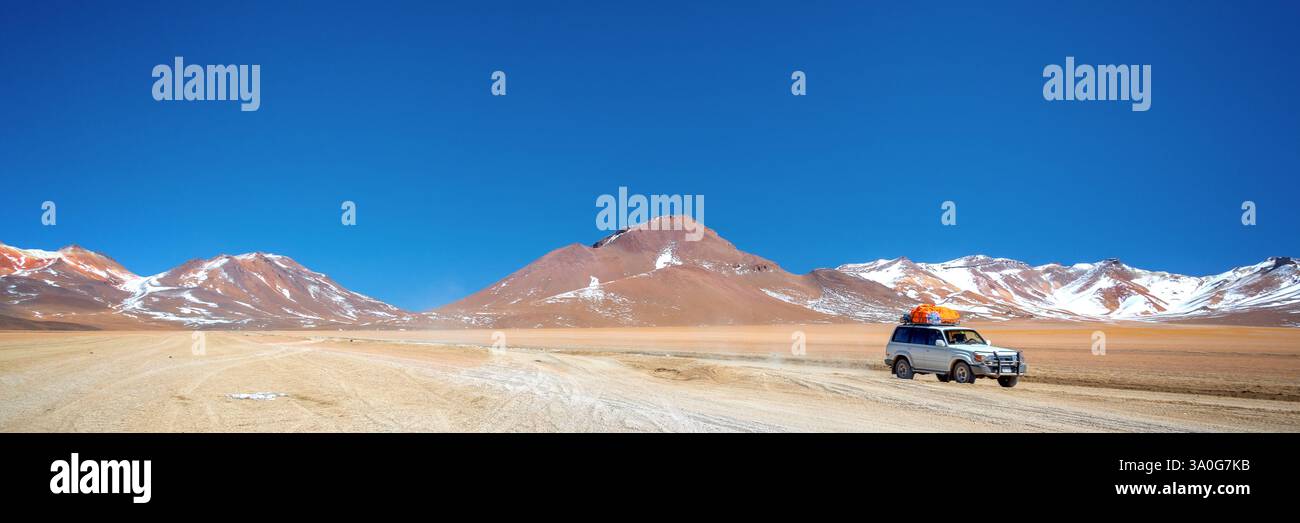 Auto 4x4 su una strada sterrata a Sud Lipez in Bolivia, paesaggio panoramico, banner web di viaggi avventurosi Foto Stock