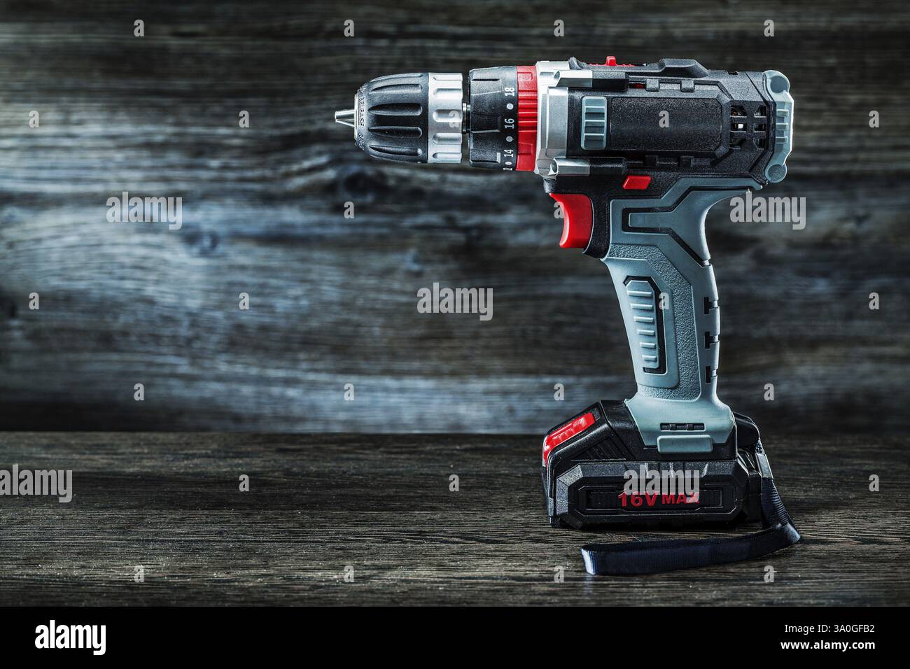 Trapano avvitatore elettrico a batteria su fondo in legno vintage Foto Stock