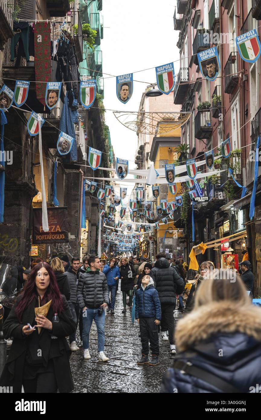 NAPOLI, ITALIA - 14 GENNAIO 2024: Una strada con i pennant della squadra di calcio FC Napoli, campione d'Italia e crod di persone sotto Foto Stock
