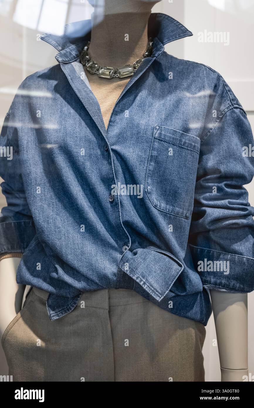 Abbigliamento estivo casual per la stagione della moda su manichini femminili. Camicia da donna in denim blu su un manichino in un negozio di abbigliamento. Luce per la visione anteriore Foto Stock