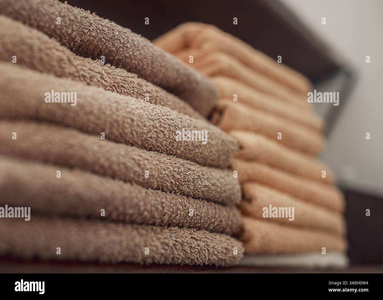 Una pila di asciugamani puliti in un salone di bellezza preparato per i clienti. Atmosfera accogliente del parrucchiere Foto Stock