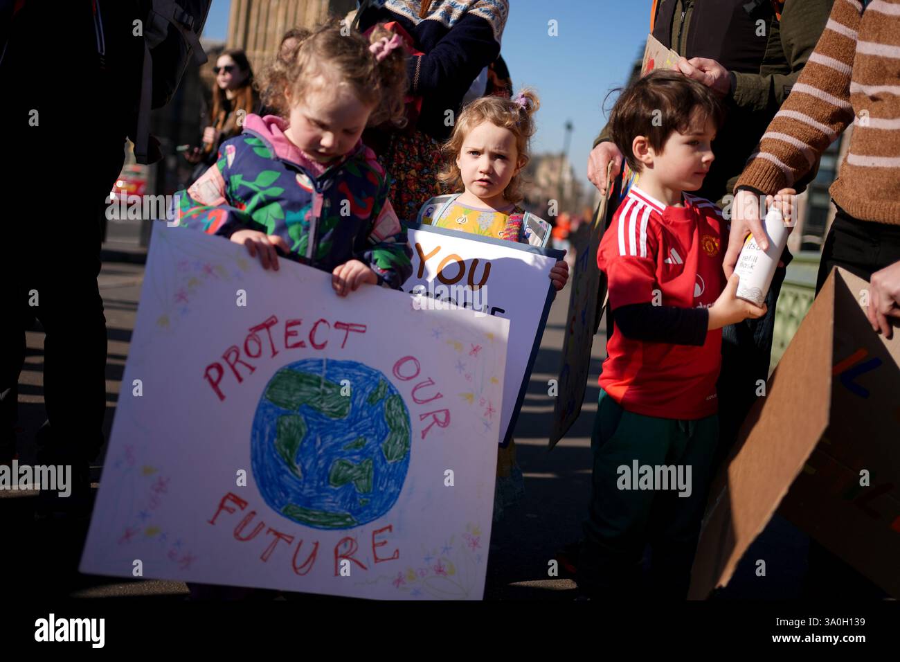 Genitori e bambini al di fuori della camera del Parlamento di Londra prima di incontrare i parlamentari per invitarli a proteggere il futuro dei loro figli opponendosi a tutte le nuove attività di estrazione di petrolio e gas nel Regno Unito. L'evento fa parte di una "lobby per famiglie" organizzata dai genitori del gruppo climatico per il futuro. Data foto: Martedì 4 marzo 2025. Foto Stock