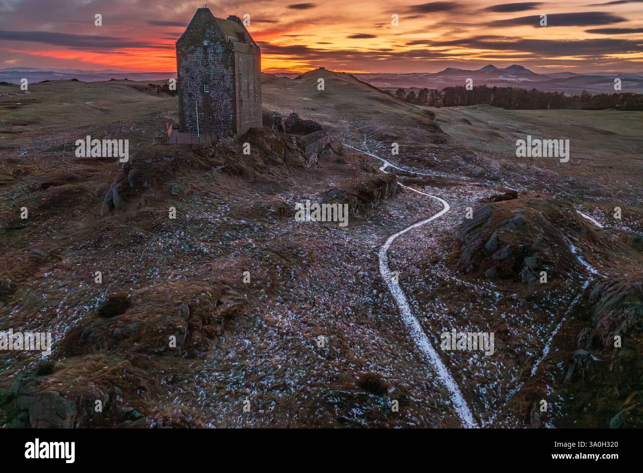 Tramonto ghiacciato alla Smailholm Tower con le Eildon Hills, nella marcia media delle terre di confine scozzesi, vicino a Kelso, Roxburghshire, Scottish Borders Foto Stock