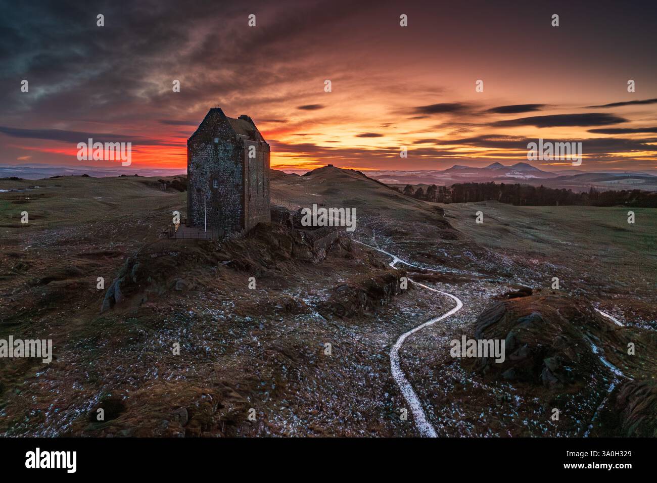 Tramonto ghiacciato alla Smailholm Tower con le Eildon Hills, nella marcia media delle terre di confine scozzesi, vicino a Kelso, Roxburghshire, Scottish Borders Foto Stock