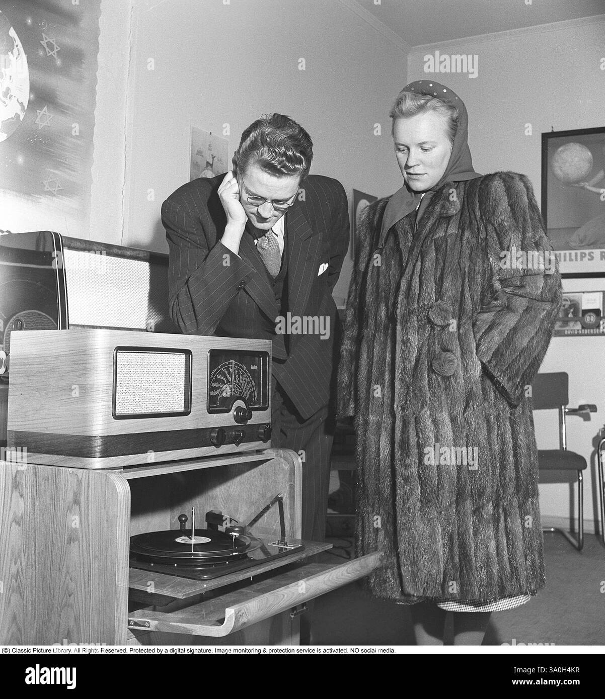 Inger Hoddø. Moglie di Oskar Hoddø (1916-1943) è stata una cantante norvegese, compositore e combattente della resistenza. Hoddø è meglio conosciuto per aver scritto il testo del valzer «Nidelven stille og vakker du er». La canzone fu un successo locale a Trondheim per molto tempo, ma divenne un successo in tutto il mondo. Inger Hoddø è fotografato nel negozio di musica di Kjell Rian a Trondheim. Kjell è stato quello che ha arrangiato la melodia e l'ha fatta registrare. Inger ha in mano un libretto di spartiti con Nidelven e un'illustrazione di Den gamle bybro a Trondheim sul davanti. Kristoffersson rif. U41-9 Foto Stock