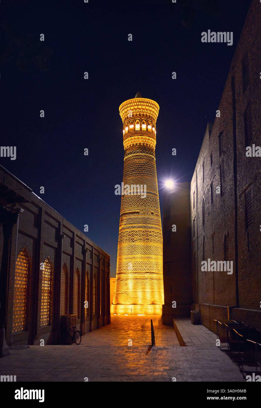 Vista della moschea minareto di Kalyan, madrasa masjid di notte con retroilluminazione gialla a Bukhara, Uzbekistan Foto Stock