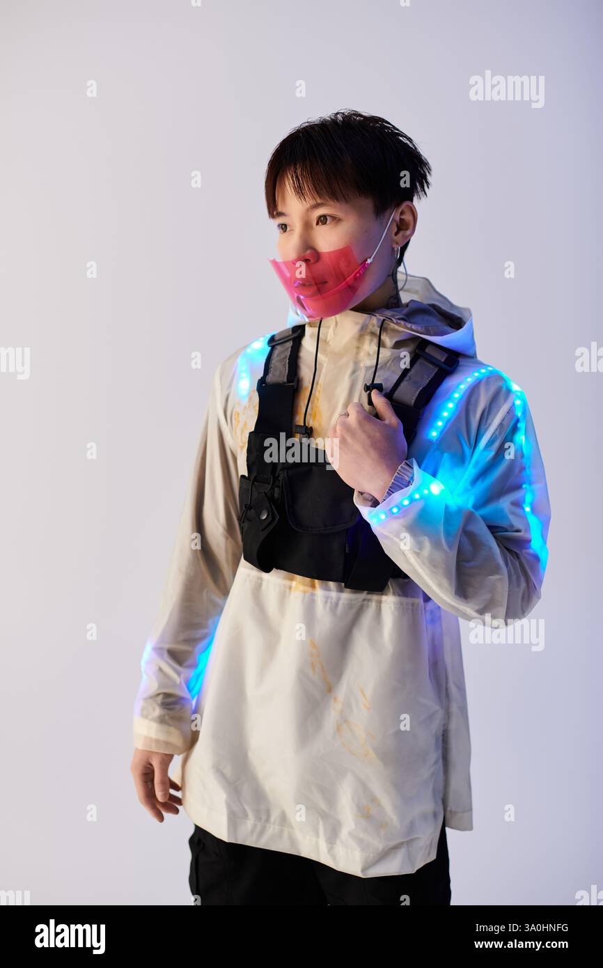 Un giovane ed elegante asiatico presenta con sicurezza un outfit con accenti LED. Foto Stock