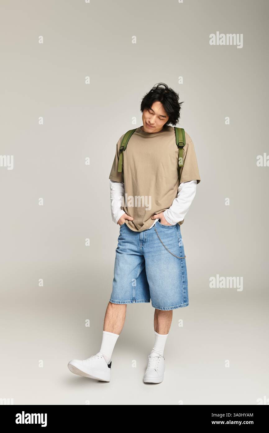Il giovane uomo elegante posa con sicurezza e mostra la moda contemporanea con un'atmosfera rilassata Foto Stock