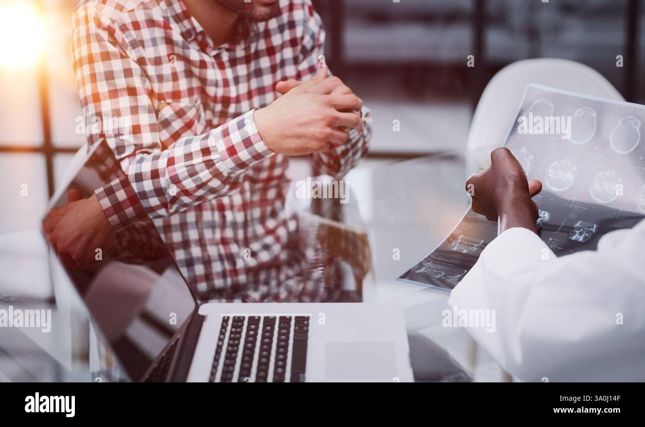 il medico e il paziente alla reception discutono della radiografia Foto Stock