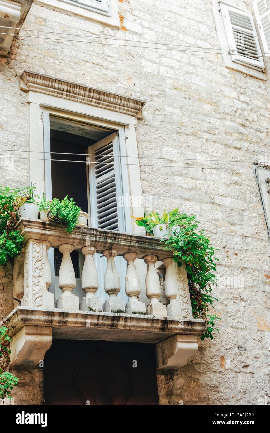 Vecchio edificio in pietra con un piccolo balcone e piante verdi. Spalato, Croazia. Foto Stock