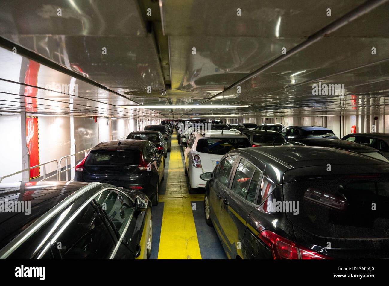 File di auto parcheggiate sul ponte di un traghetto roll-on-roll off. Foto Stock