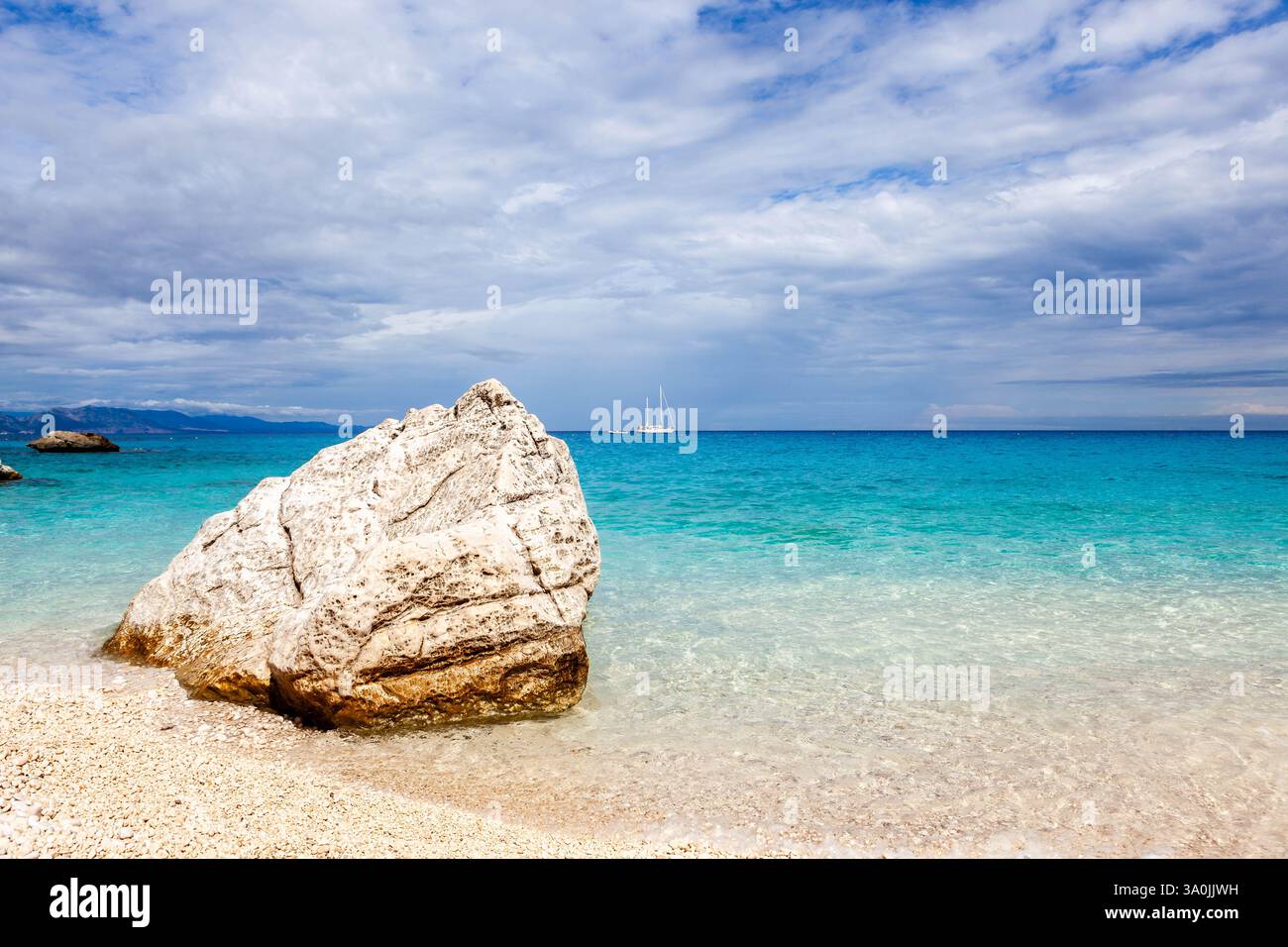 Sardegna, Italia. Mare Mediterraneo cristallino, acque turchesi smeraldo, rocce incredibili e barca a vela bianca. Foto Stock