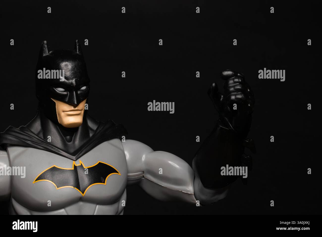 Il personaggio "Batman" solleva il pugno, isolato su un semplice sfondo nero Foto Stock