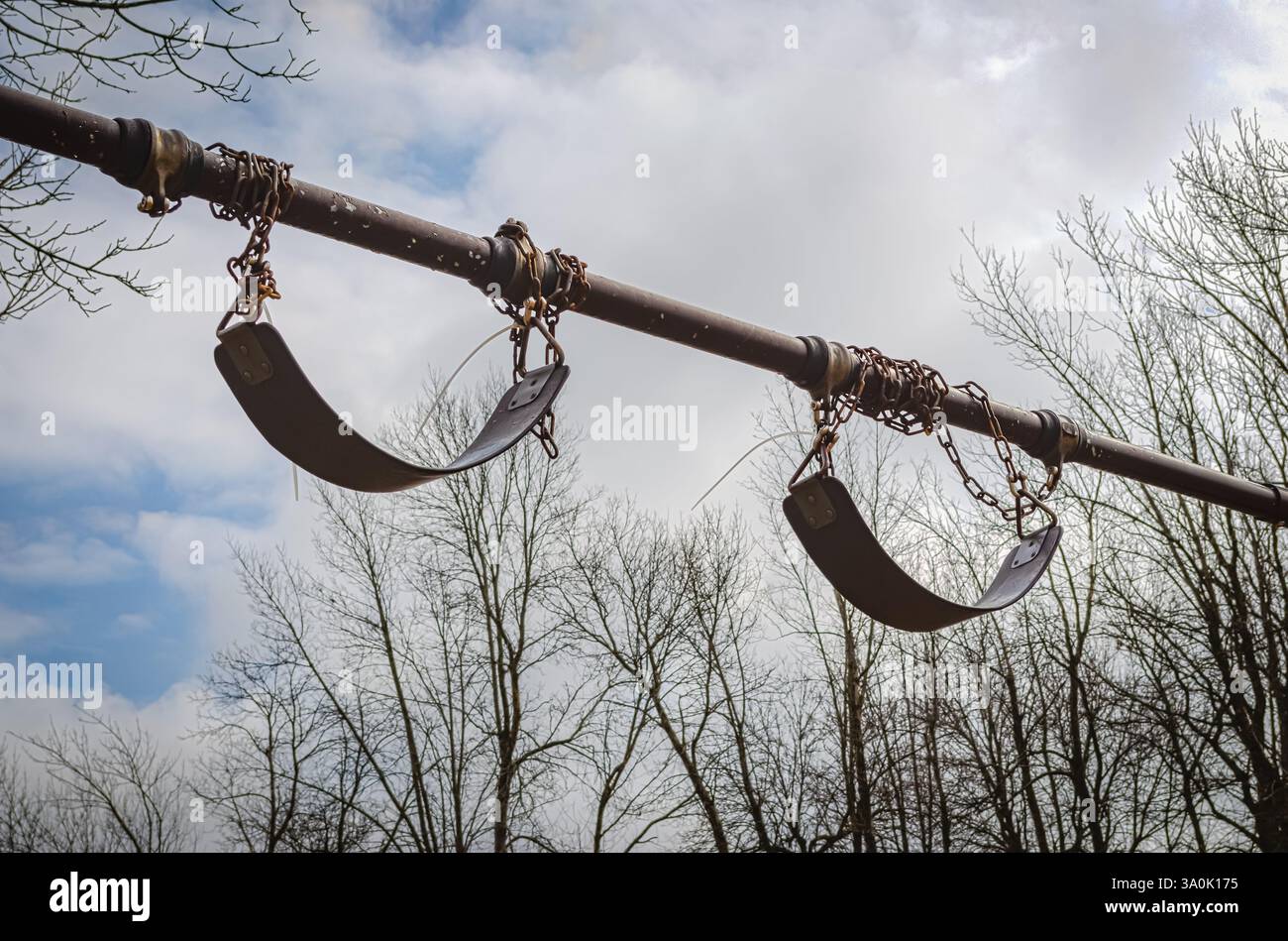 Coppia di sedi oscillanti fuori portata sulle catene contro il cielo Foto Stock