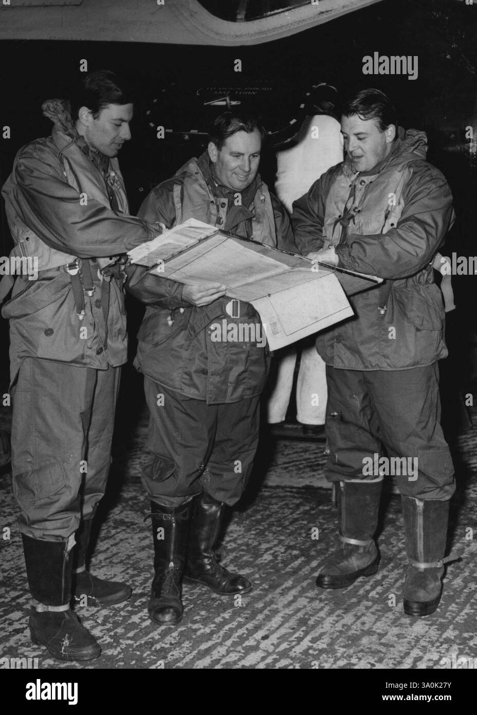 Canberra parte per l'offerta atlantica a due vie -- l'equipaggio del Canberra controlla le loro mappe prima di decollare. Sono, da sinistra a destra: Flight-Lieut. P. Hillwood (secondo pilota che porterà la macchina a casa), squadra. - Capo D.A. Watson navigatore), e Wing Commander Roland Beamont (capitano dell'aereo e capo pilota collaudatore della English Electric Company). Un bombardiere Canberra Jet e' decollato stamattina dalla stazione R.A.F. di Aldergrove, Co Antrim, Irlanda del Nord, nel tentativo di fare un bidirezionale che nessun aereo ha mai fatto prima. 26 agosto 1952. (Foto di Paul Popper). Foto Stock