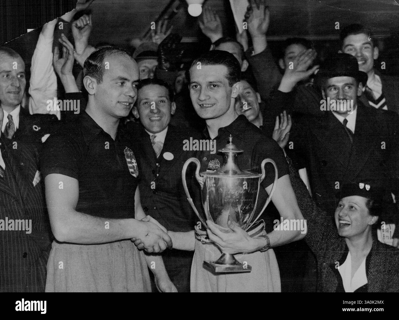 Finali dei Campionati mondiali di ping-pong allo stadio di Wembley. Barna (Ungheria) con la Coppa, congratulandosi con il suo avversario, Miklos Szabados (Ungheria) che ha battuto per vincere il campionato del mondo per la quinta volta. 17 febbraio 1935. (Foto di Keystone). Foto Stock