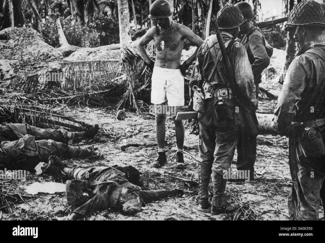 I soldati giapponesi uccisi nella loro trappola corazzata sull'atollo Makin nel Gilbert i soldati statunitensi guardano i soldati giapponesi morti che caddero dietro la prima trappola corazzata che gli americani incontrarono quando atterrarono sull'atollo di Makin nelle isole Gilbert. Le forze americane controllavano le isole vitali del gruppo Gilbert nel Pacifico meridionale 79 ore dopo il lancio dell'attacco. 22 febbraio 1944. Foto Stock