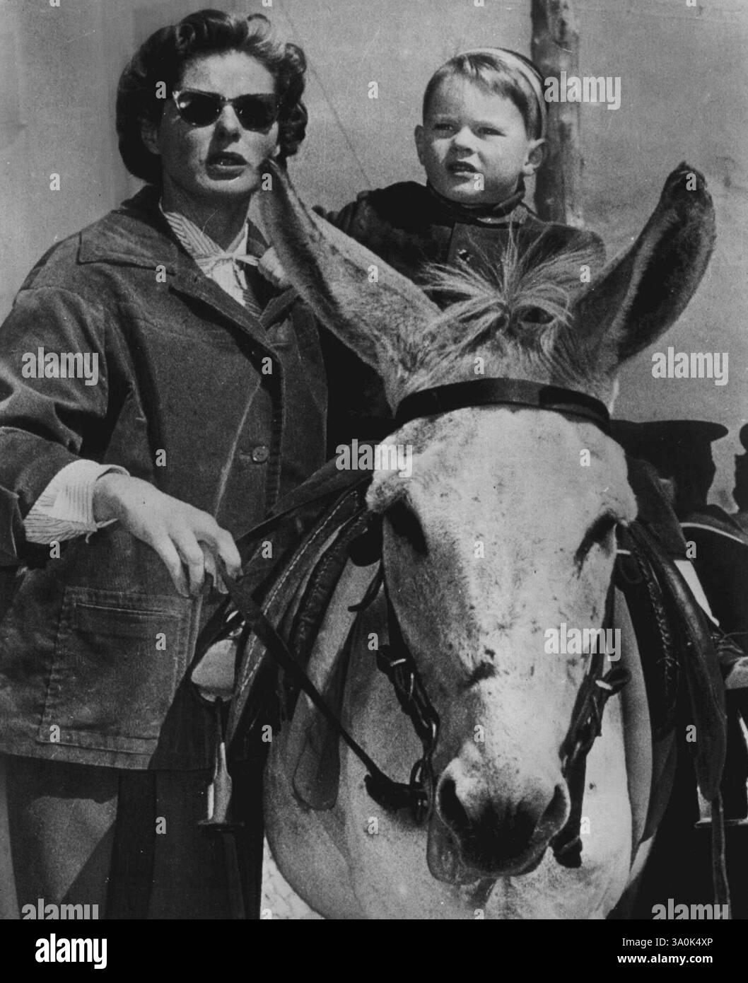 Giro sull'asino per Robertino - l'attrice Ingrid Bergman regala a suo figlio, Robertino Rossellini di tre anni, un giro sull'asino durante un picnic sull'isola di Capri il 19 marzo con suo marito il regista Roberto Rossellini. L'attrice e suo marito si sono presi il giorno libero dal loro lavoro cinematografico a Napoli. 23 marzo 1953. (Foto di AP Wirephoto) Foto Stock